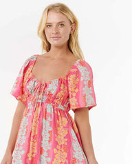 Woman wearing a pink floral dress on a white background