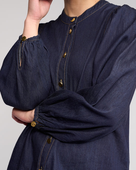 Navy blue long-sleeve shirt with gold buttons on a plain background