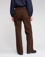 Person wearing brown pants and a blue shirt on a white background