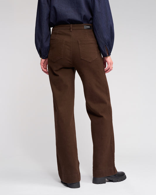 Person wearing brown pants and a blue shirt on a white background