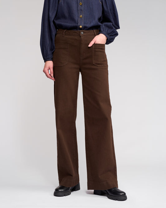Person wearing brown pants and a blue shirt on a white background