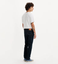 Person wearing dark jeans and a white t-shirt on a white background