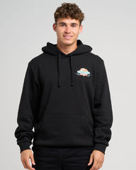 Man wearing a black hoodie with a logo on a gray background