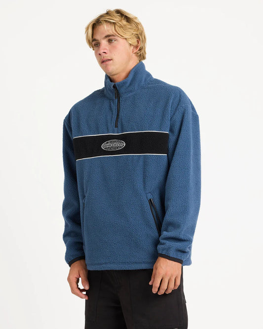 Person wearing a blue pullover with a logo on a white background