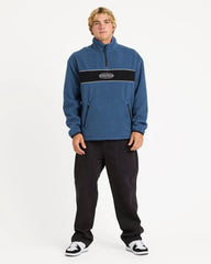 Person wearing a blue pullover with a logo on a white background