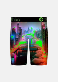 Ethika boxer briefs featuring a vibrant, neon-lit futuristic cityscape print with glowing green and pink lights over a dark skyline and water, shown against a light gray background.