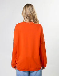 Person wearing an orange sweatshirt on a plain background