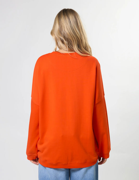 Person wearing an orange sweatshirt on a plain background