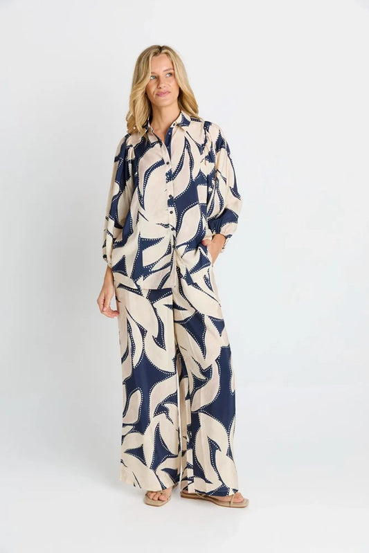 Woman wearing a patterned jumpsuit on a white background