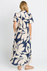 Woman wearing a long dress with a blue and white pattern on a white background