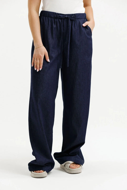 Navy blue pants worn by a person on a white background