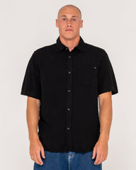 Man wearing a black short-sleeve shirt against a white background