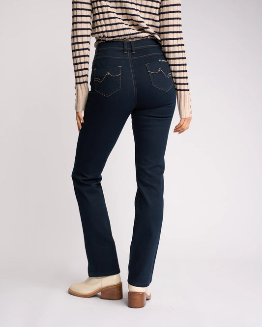 Person wearing dark blue jeans and a striped shirt on a light gray background
