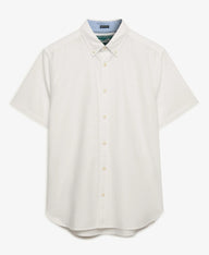 A short-sleeve button-down shirt in off-white, featuring a classic collar, matching buttons, and a visible light blue inner collar lining. The brand label inside the collar reads 'SUITABLE'.