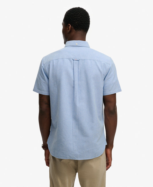 Man wearing a light blue short-sleeve shirt on a white background