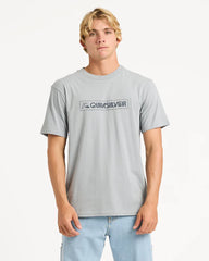 Person wearing a gray Quiksilver t-shirt on a white background