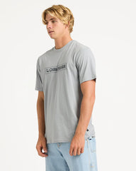 Man wearing a gray t-shirt with a quiksilver logo on a white background
