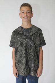 Young person wearing a camouflage-patterned t-shirt on a plain background