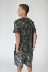Child wearing a camouflage t-shirt and shorts on a white background