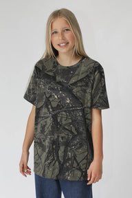 Young girl wearing a camouflage-patterned t-shirt on a white background