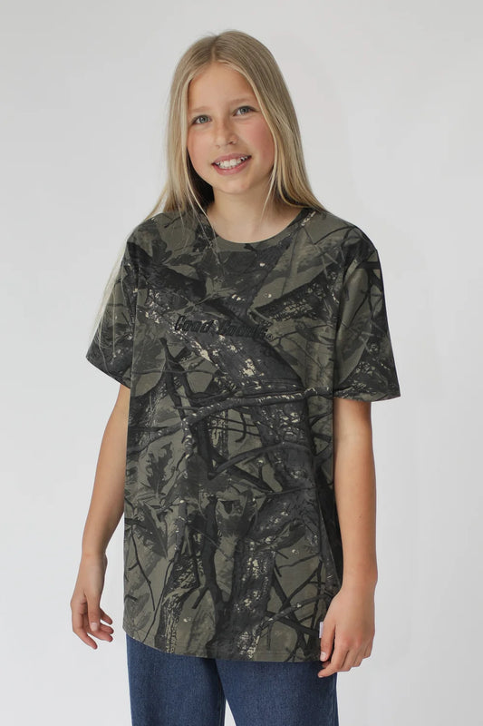 Young girl wearing a camouflage-patterned t-shirt on a white background