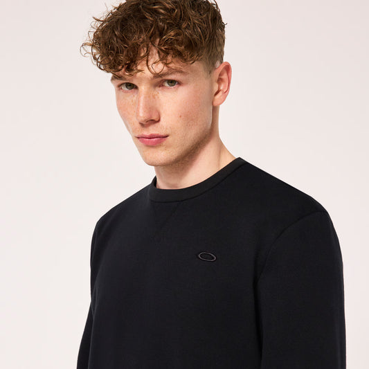 Man wearing a black sweatshirt with a logo on a light gray background