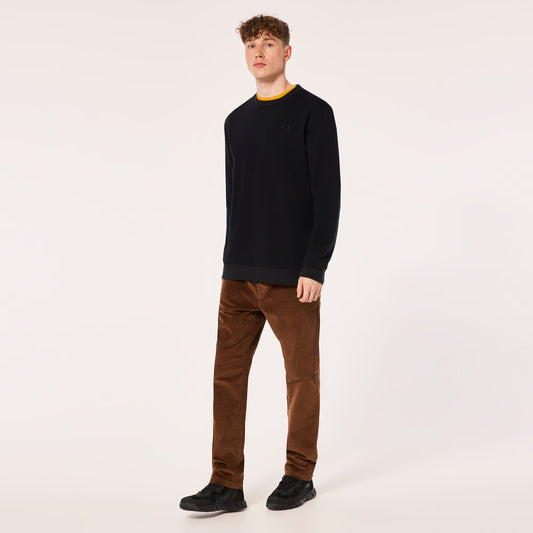 Man wearing a black sweater and brown pants on a white background