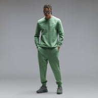 Person wearing a green outfit with a logo on a gray background