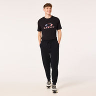 Person wearing a black t-shirt with a logo and black pants on a white background