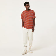 Man wearing a red and white striped shirt and white pants on a white background