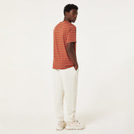 Person wearing a striped shirt and white pants on a plain background