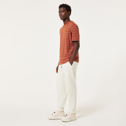 Man wearing a striped shirt and white pants on a white background