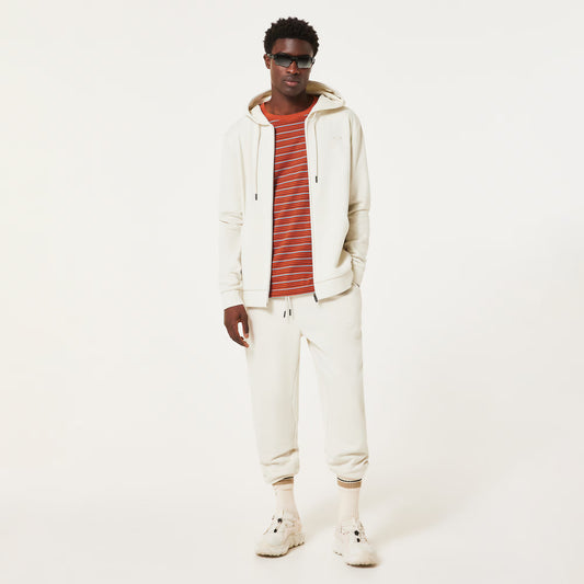 Man wearing a white hoodie, striped shirt, and pants on a white background