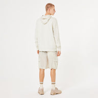 Person wearing a beige hoodie and cargo shorts on a white background