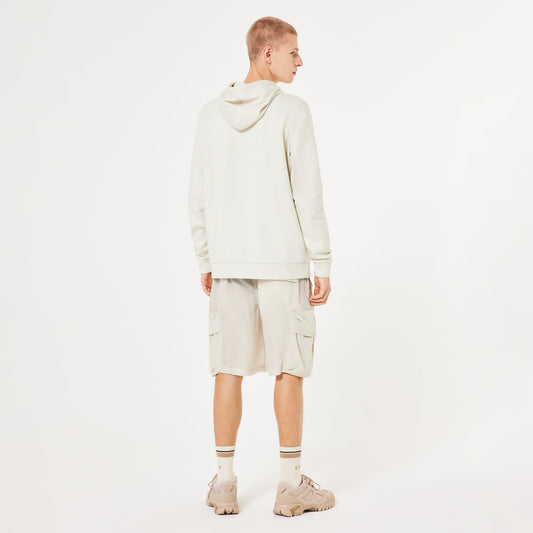 Person wearing a beige hoodie and cargo shorts on a white background
