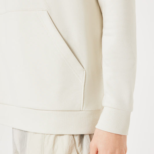 Close-up of a person wearing a beige sweater on a white background