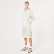 Person wearing a beige hoodie and shorts set on a white background