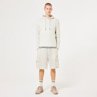 Person wearing a beige hoodie and shorts set on a white background
