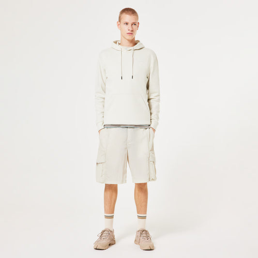 Person wearing a beige hoodie and shorts set on a white background