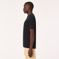Man wearing a black t-shirt and beige pants on a white background