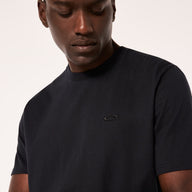Man wearing a black t-shirt with a logo on a plain background