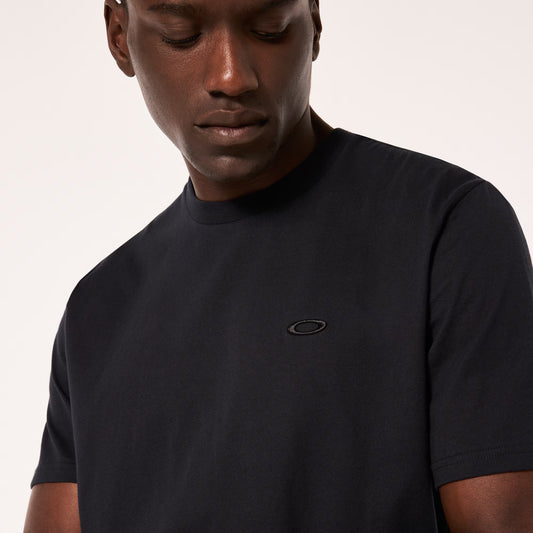 Man wearing a black t-shirt with a logo on a plain background