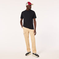 Man wearing a black t-shirt, beige pants, and a red and white cap on a white background
