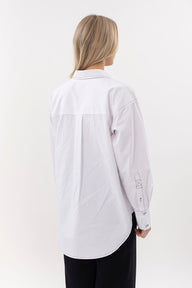 Person wearing a white shirt on a plain background