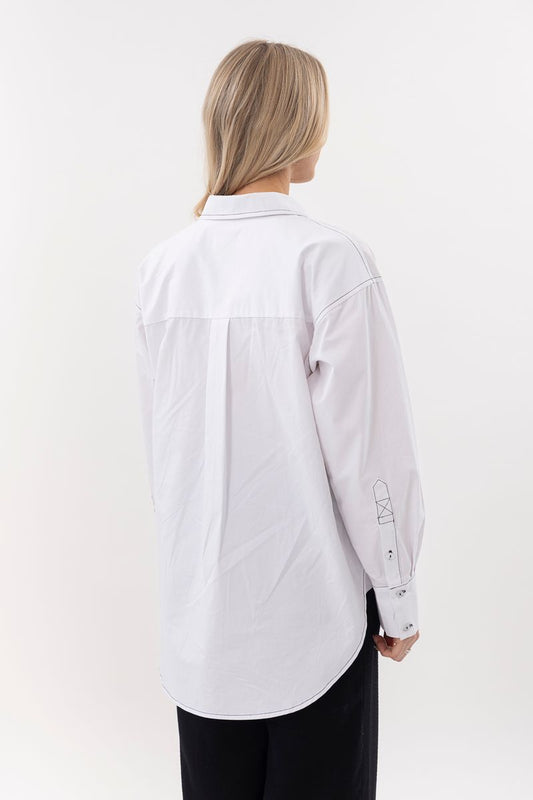 Person wearing a white shirt on a plain background