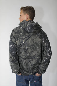 Person wearing a dark camouflage jacket on a plain background
