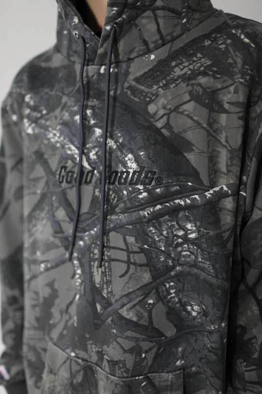 Camouflage hoodie with 'Good Goods' branding on a neutral background