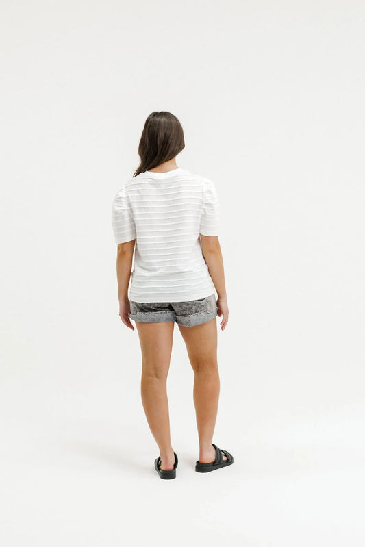 Person wearing a striped shirt and shorts on a white background
