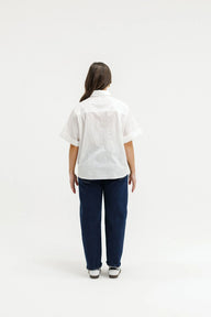 Person wearing a white shirt and blue pants on a white background