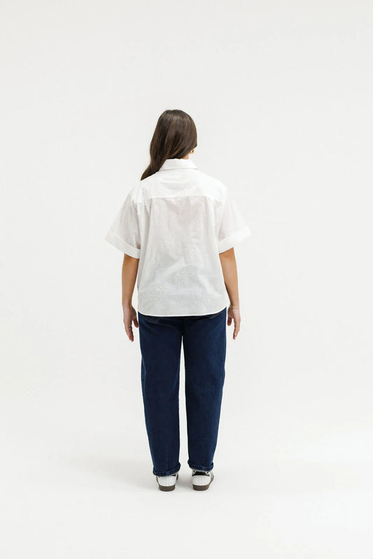 Person wearing a white shirt and blue pants on a white background